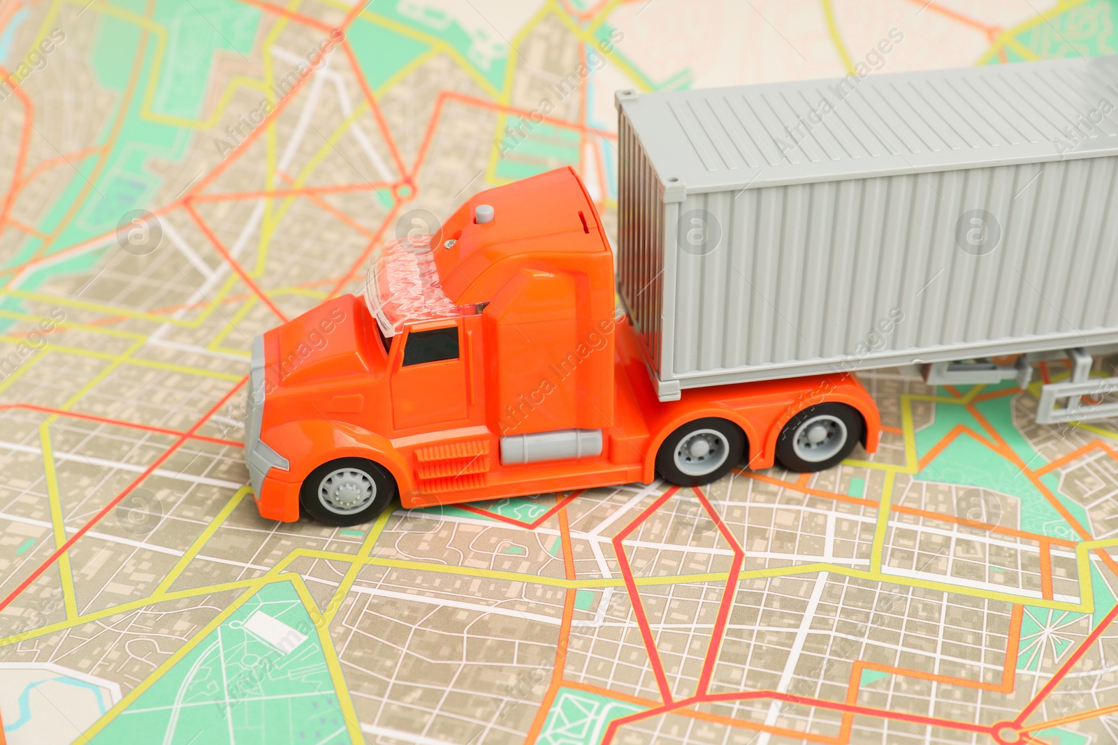 Photo of Toy truck on city map, closeup. Logistics concept