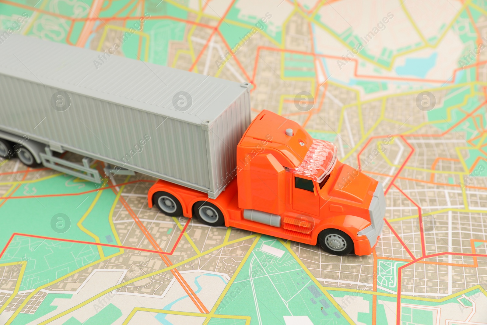 Photo of Toy truck on city map, closeup. Logistics concept