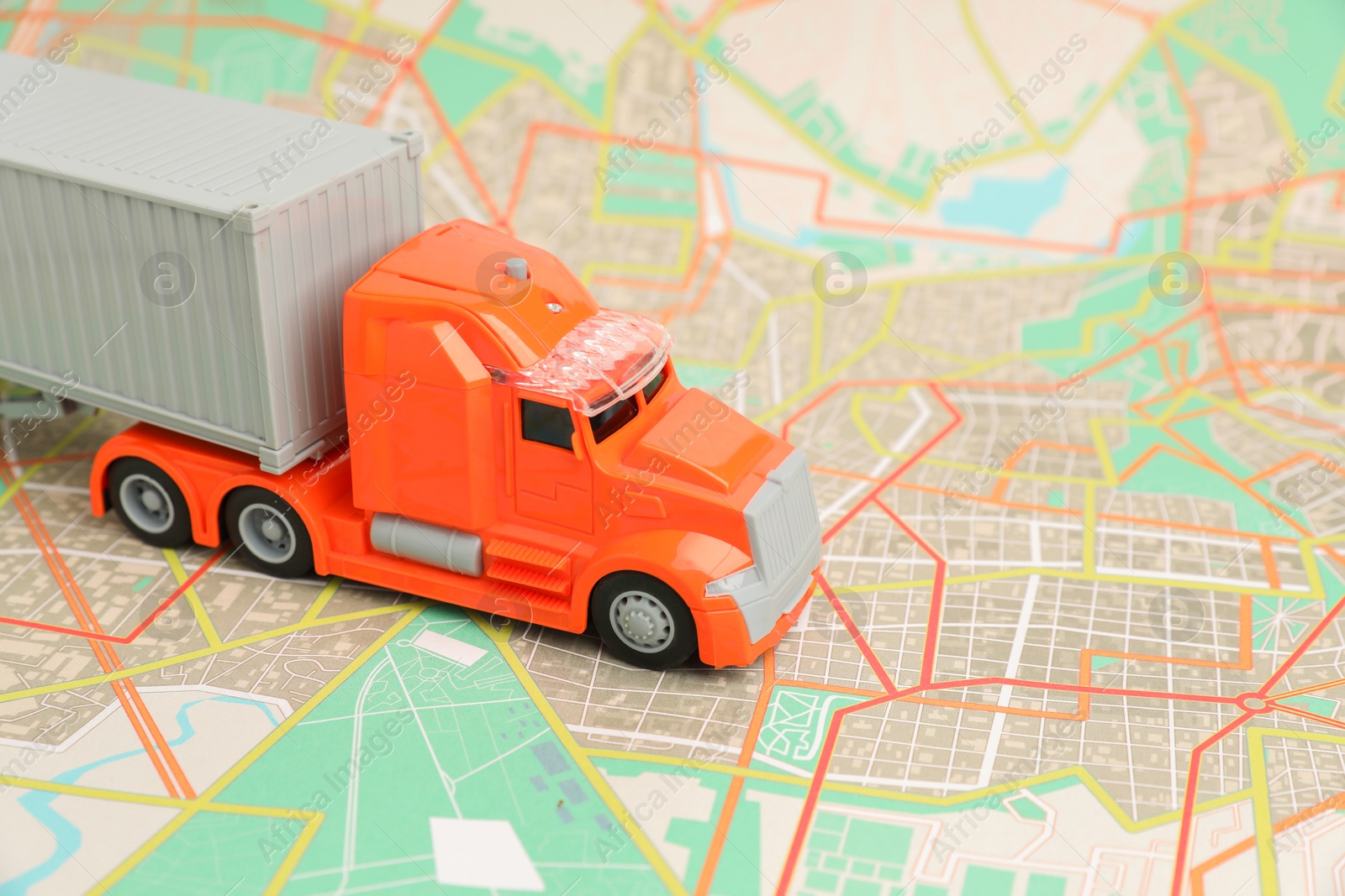 Photo of Toy truck on city map, closeup. Logistics concept