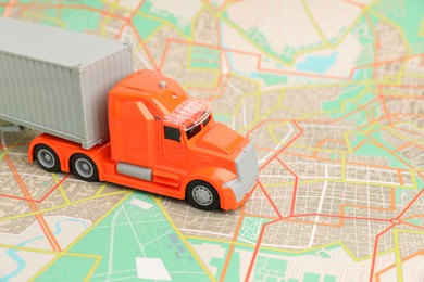 Photo of Toy truck on city map, closeup. Logistics concept