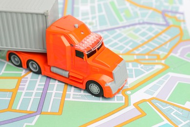 Photo of Toy truck on city map, closeup. Logistics concept