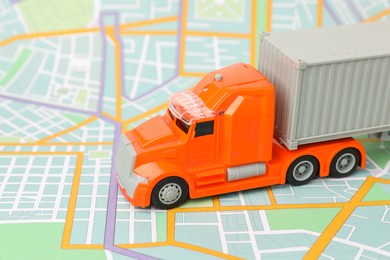 Photo of Toy truck on city map, closeup. Logistics concept