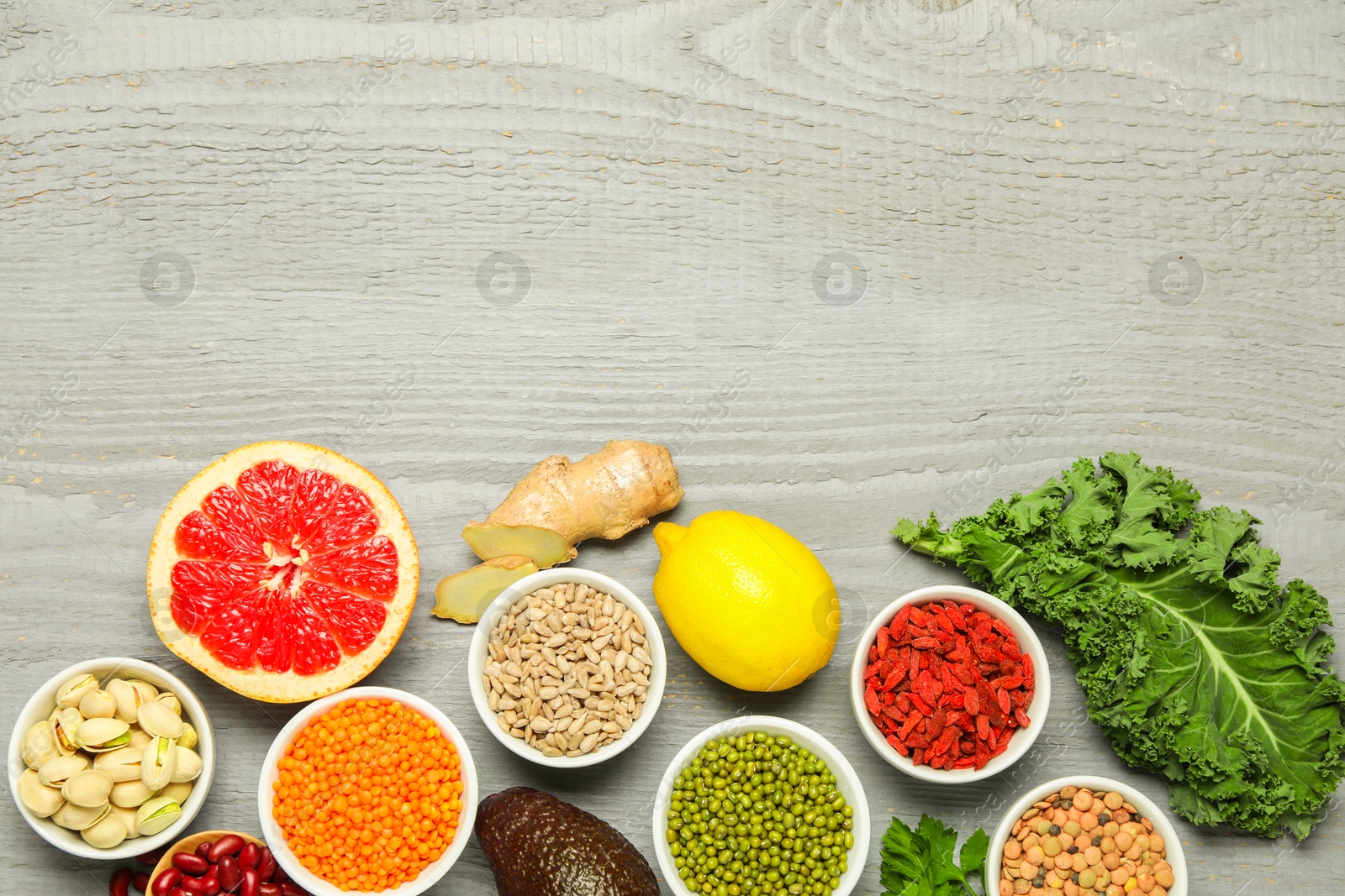 Photo of Superfood. Different healthy food products on grey wooden table, flat lay