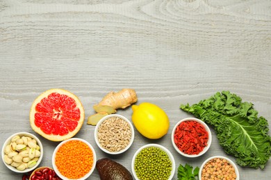 Photo of Superfood. Different healthy food products on grey wooden table, flat lay