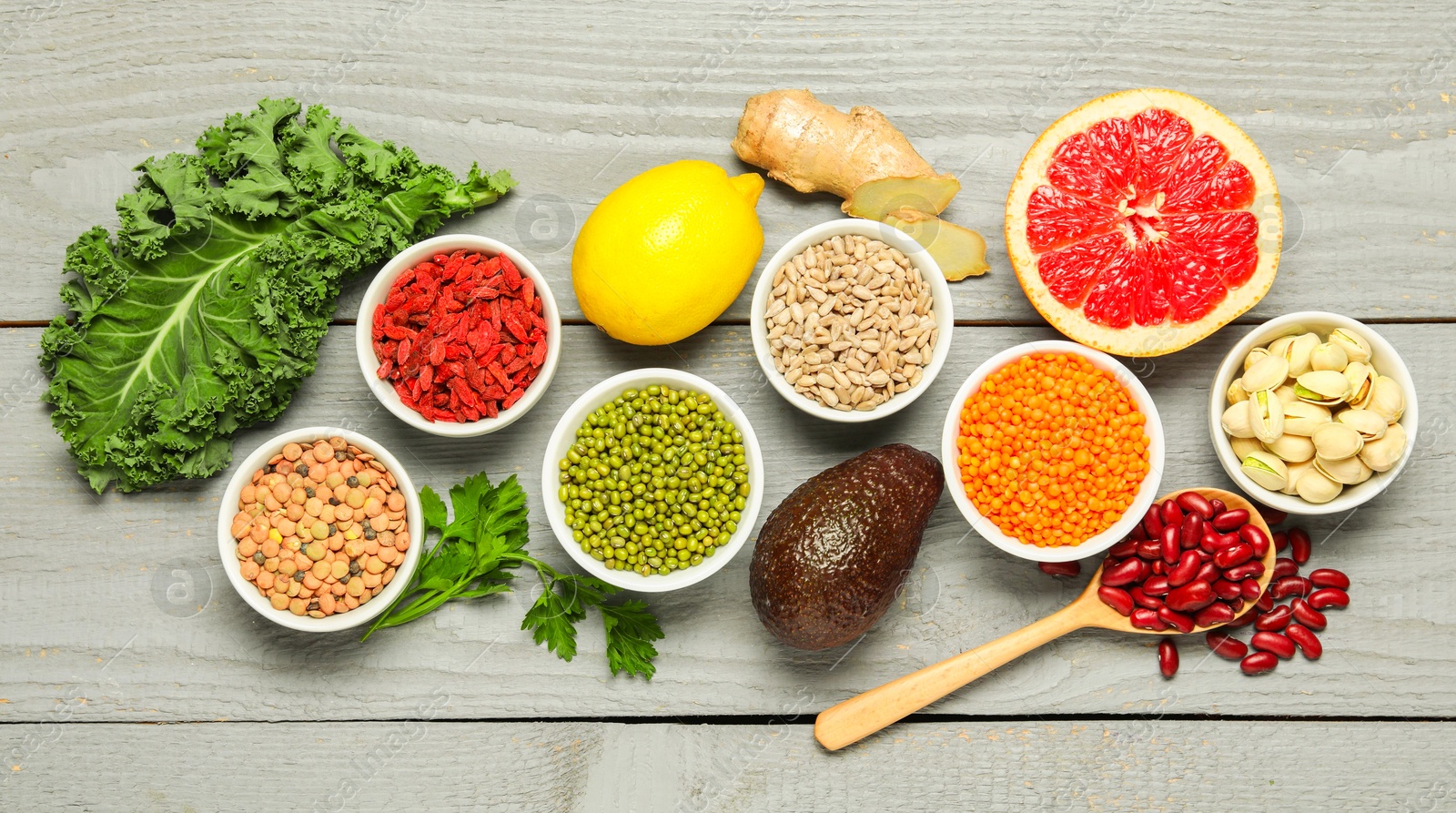 Photo of Superfood. Different healthy food products on grey wooden table, flat lay