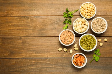 Photo of Superfood. Different healthy food products on wooden table, flat lay. Space for text