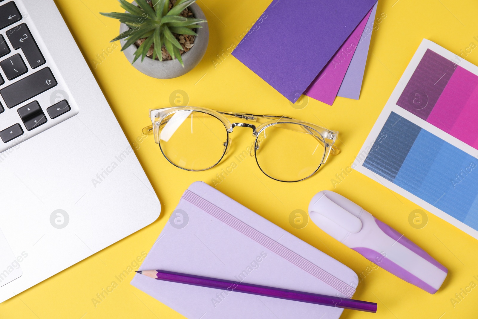 Photo of Designer's workplace. Flat lay composition with stationery and laptop on yellow background