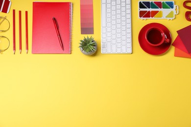 Photo of Designer's workplace. Flat lay composition with stationery, keyboard and cup of coffee on yellow background, space for text