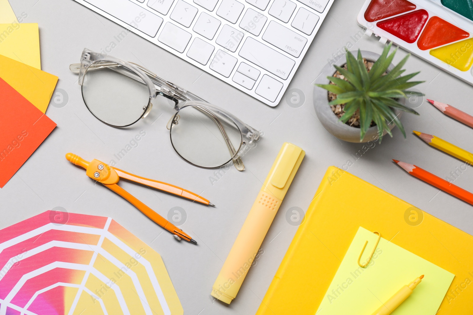 Photo of Designer's workplace. Flat lay composition with stationery and keyboard on light grey background