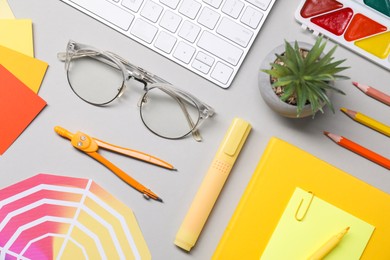 Photo of Designer's workplace. Flat lay composition with stationery and keyboard on light grey background