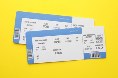 Photo of Travel agency. Flight tickets on yellow background, top view