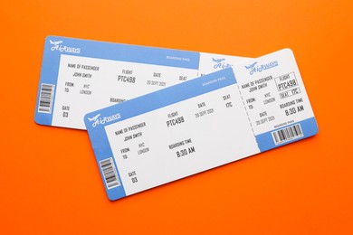 Photo of Travel agency. Flight tickets on orange background, top view. Space for text