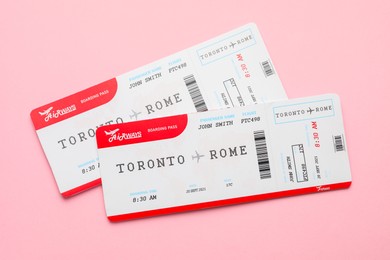 Photo of Travel agency. Flight tickets on pink background, top view