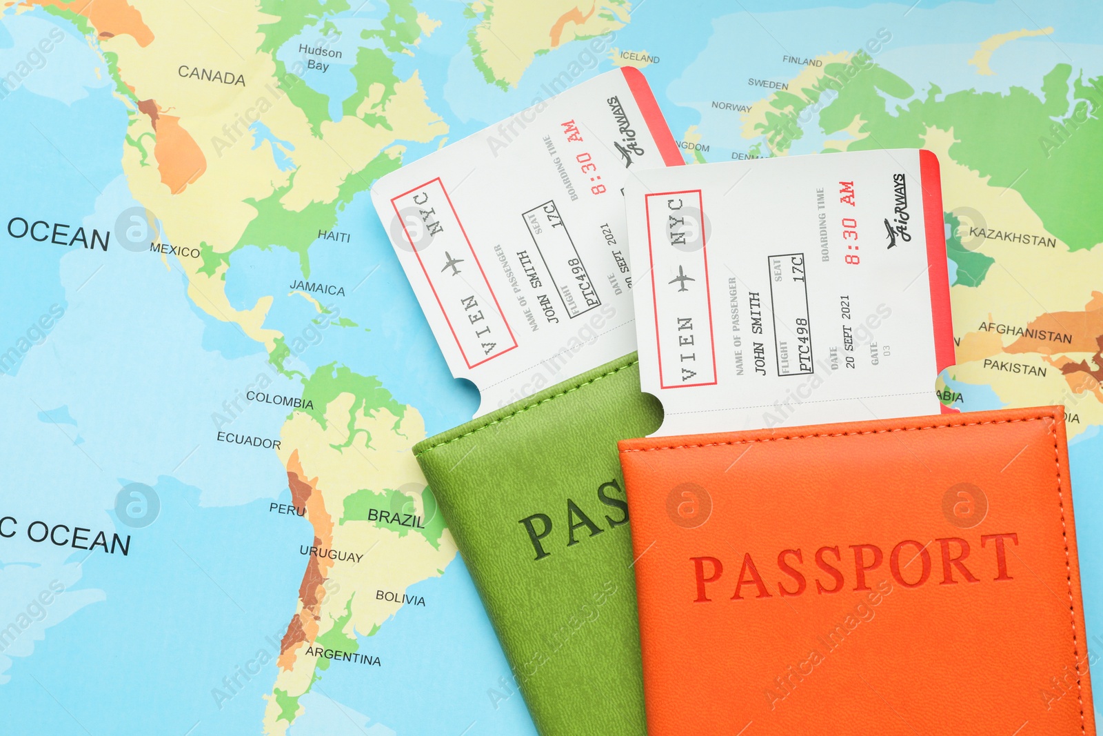 Photo of Travel agency. Flight tickets and passports on world map, flat lay