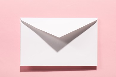 Paper envelope on pink background, top view. Mockup for design