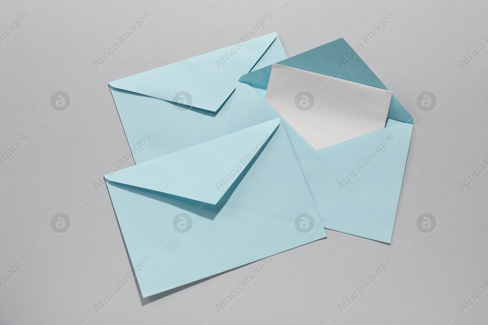 Photo of Paper envelopes with letter on grey background, flat lay. Mockup for design