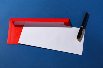 Photo of Paper envelopes and fountain pen on blue background, above view. Mockup for design