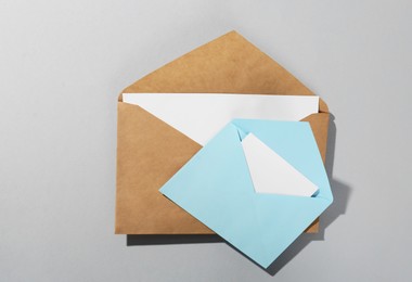 Paper envelopes with letters on grey background, above view. Mockup for design