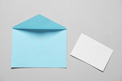 Photo of Paper envelope with letter on gray background, flat lay. Mockup for design