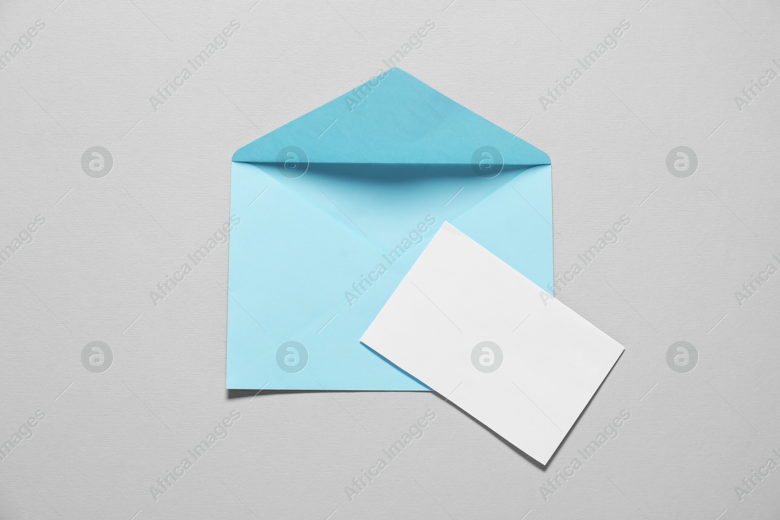 Photo of Paper envelope with letter on gray background, top view. Mockup for design