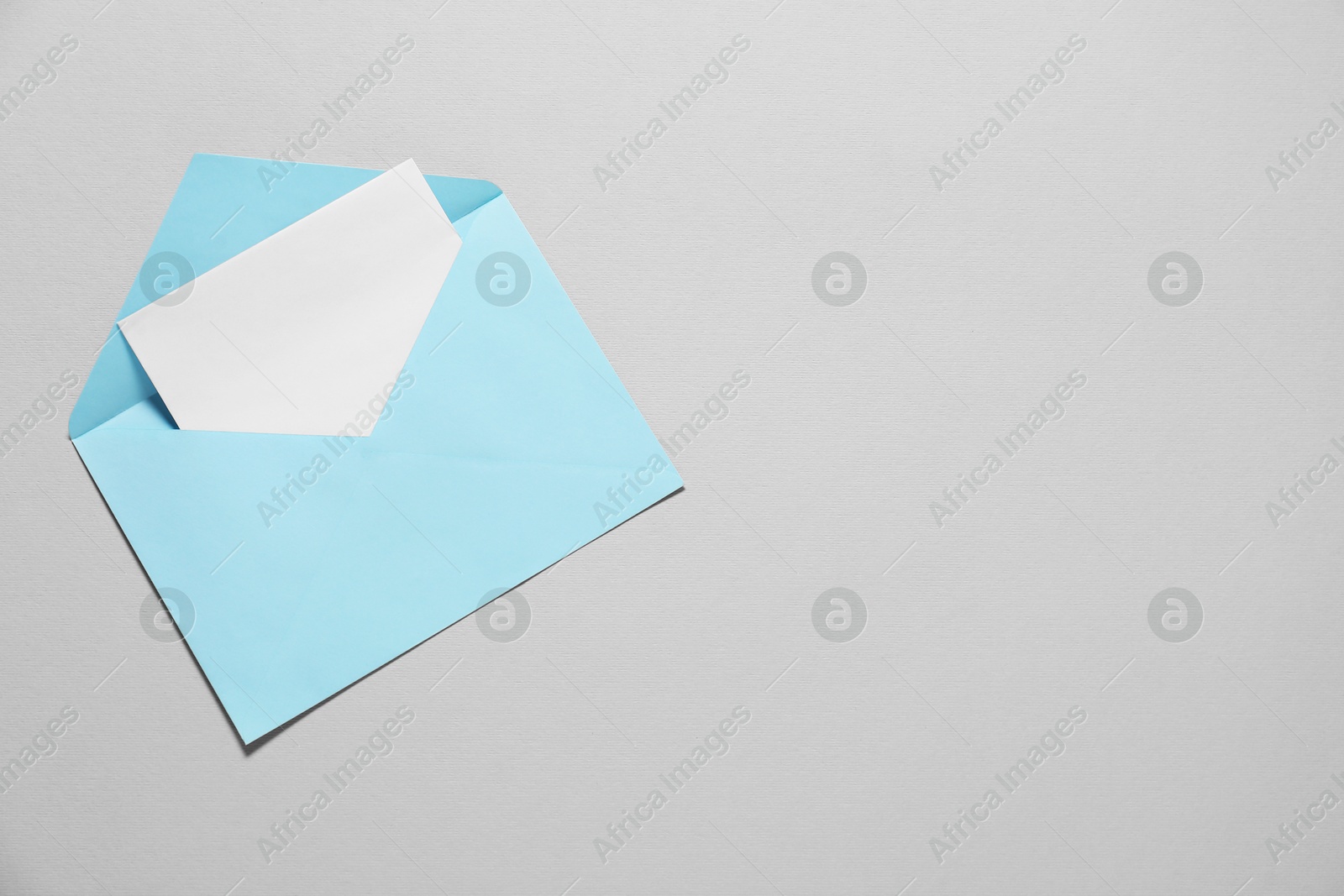 Photo of Paper envelope with letter on gray background, top view. Mockup for design