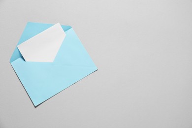 Paper envelope with letter on gray background, top view. Mockup for design