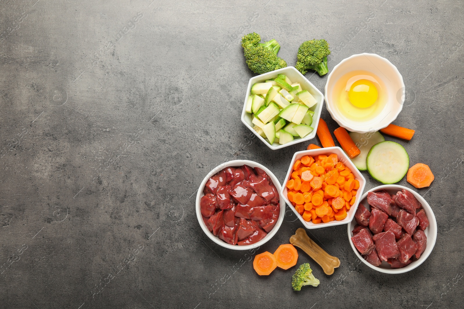 Photo of Pet food. Natural products on grey table, top view. Space for text