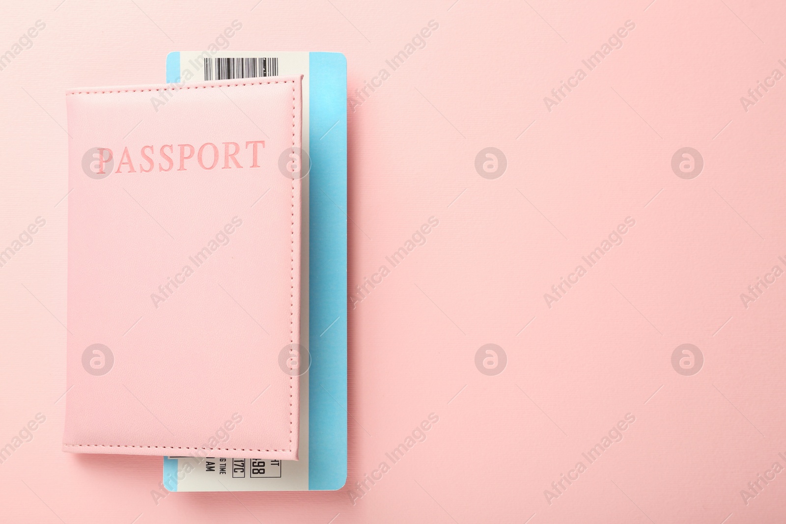 Photo of Passport with ticket on pink background, top view. Space for text