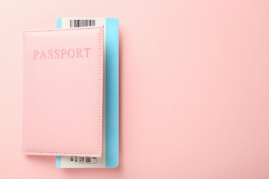 Photo of Passport with ticket on pink background, top view. Space for text