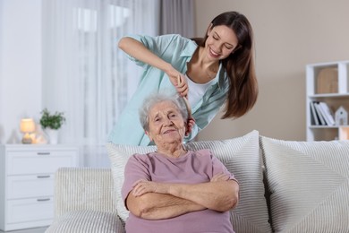 Photo of Woman brushing senior lady with brush indoors