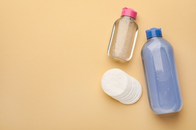 Photo of Clean cotton pads and micellar water on beige background, flat lay. Space for text