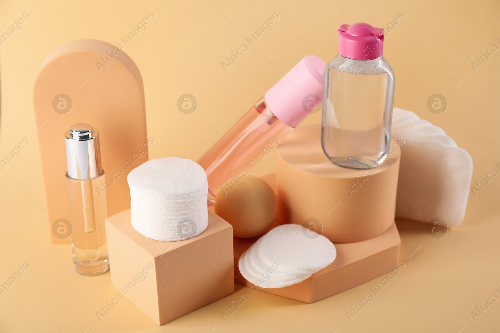 Photo of Clean cotton pads and cosmetic products on beige background