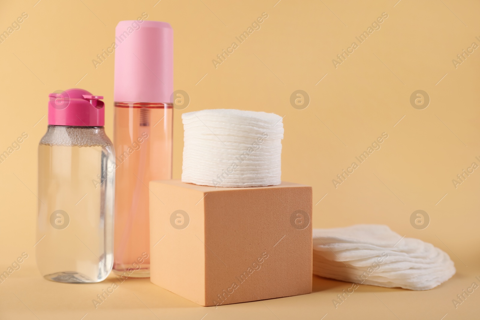 Photo of Clean cotton pads and micellar water on beige background