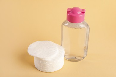 Photo of Clean cotton pads and micellar water on beige background, closeup. Space for text