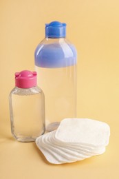 Photo of Clean cotton pads and micellar water on beige background