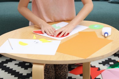 Photo of Girl making art project at table indoors, closeup