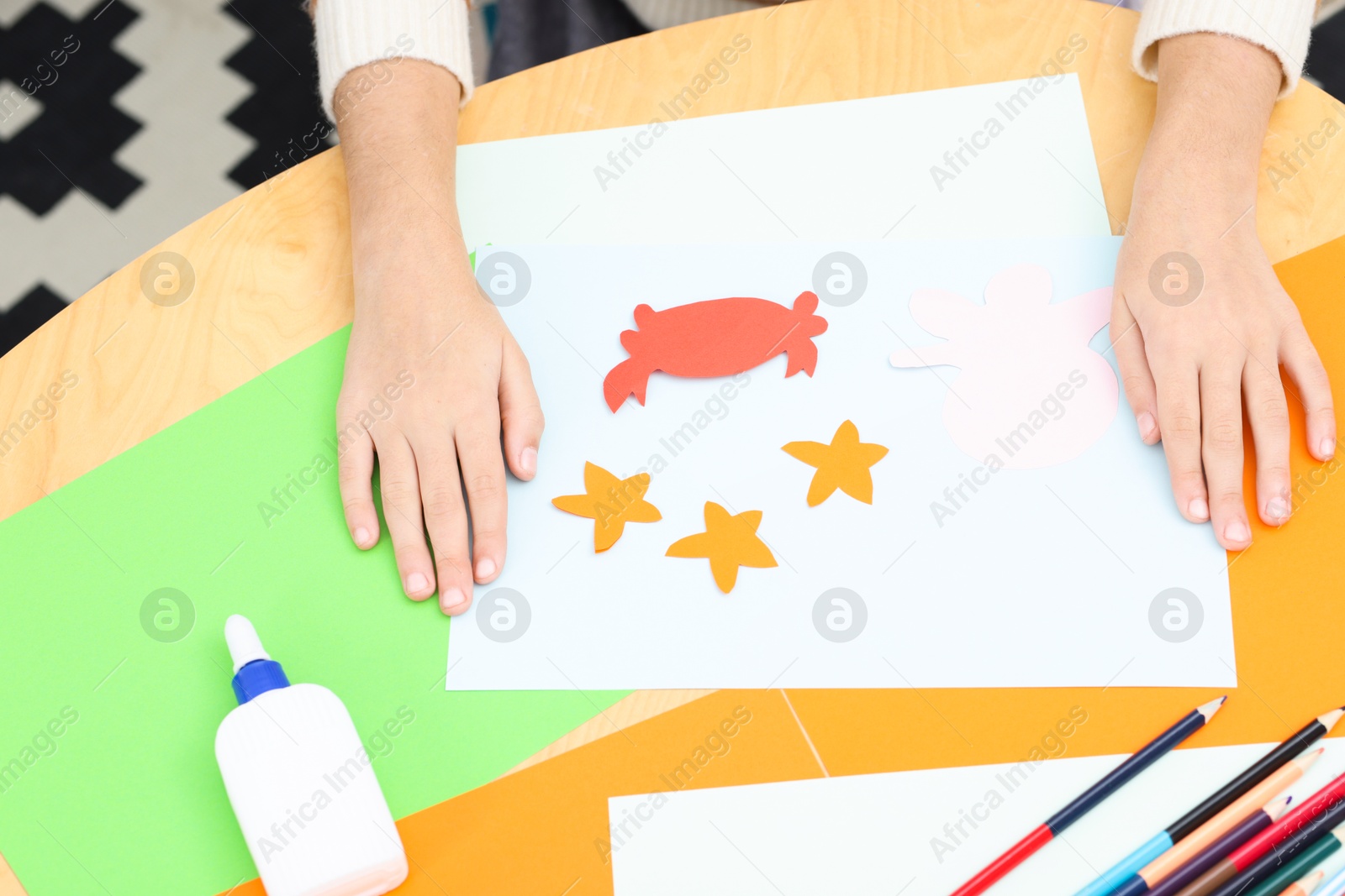 Photo of Girl making art project at table indoors, closeup