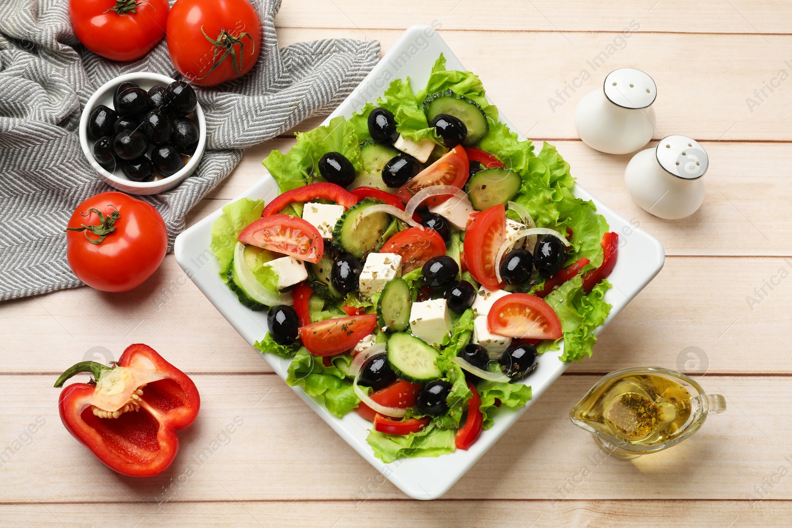 Delicious fresh Greek salad on white wooden table, flat lay Photo of Delicious fresh Greek salad on white wooden table, flat lay