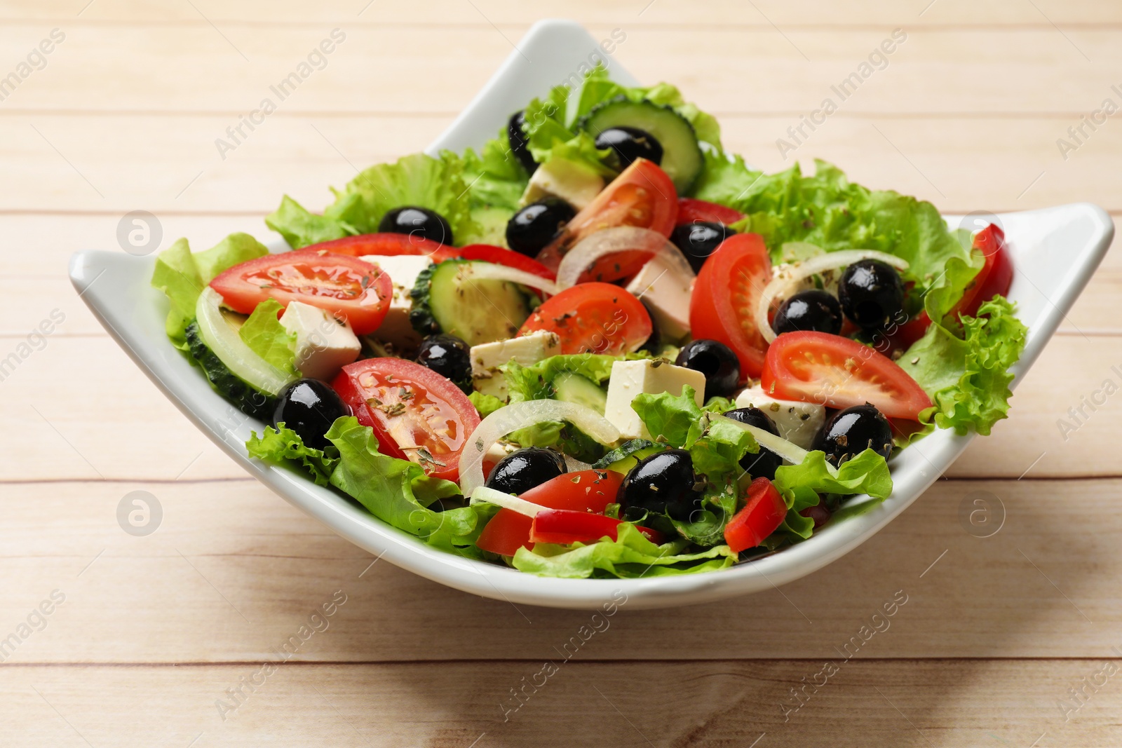 Delicious fresh Greek salad on white wooden table, closeup Photo of Delicious fresh Greek salad on white wooden table, closeup