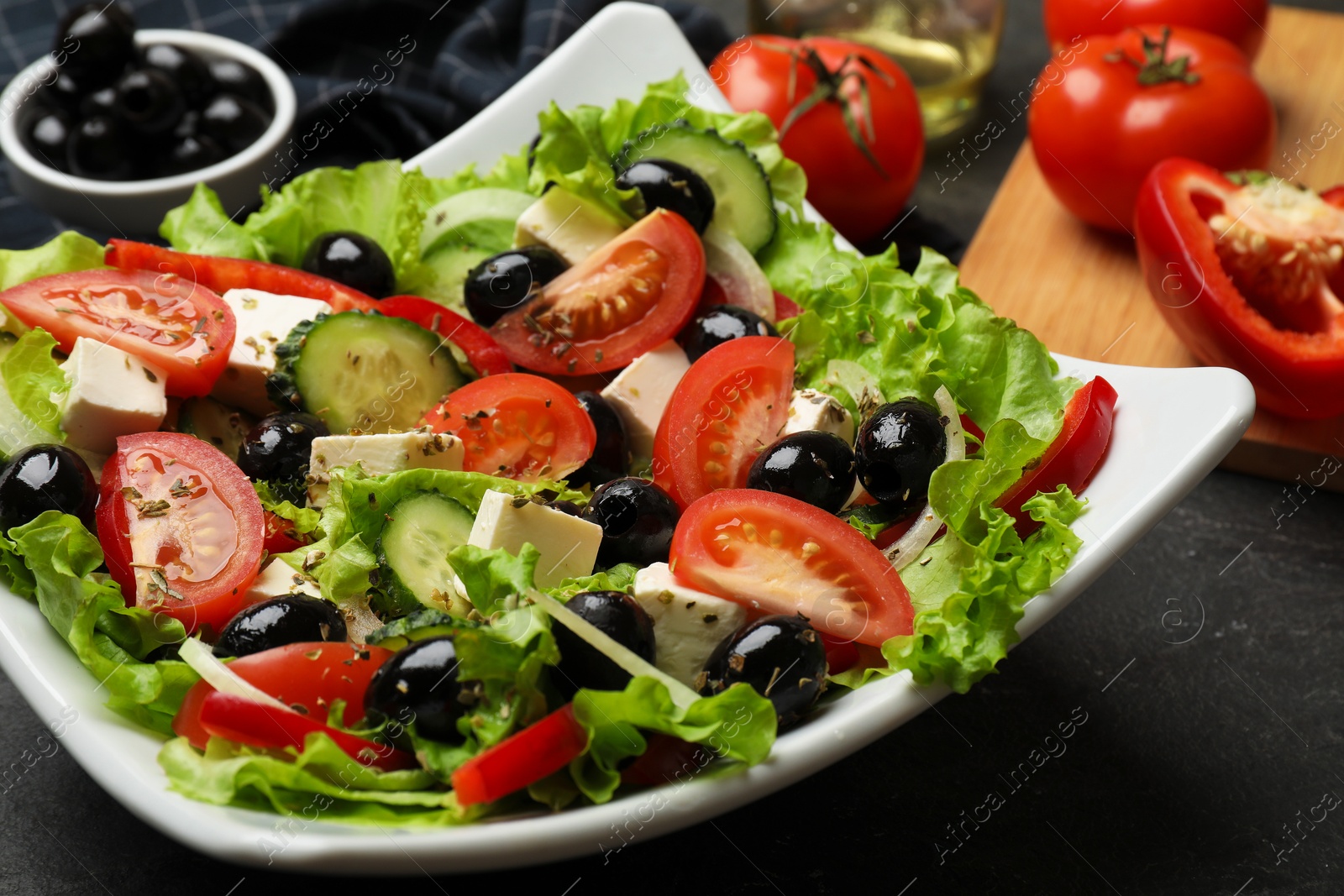 Delicious fresh Greek salad on black table, closeup Photo of Delicious fresh Greek salad on black table, closeup