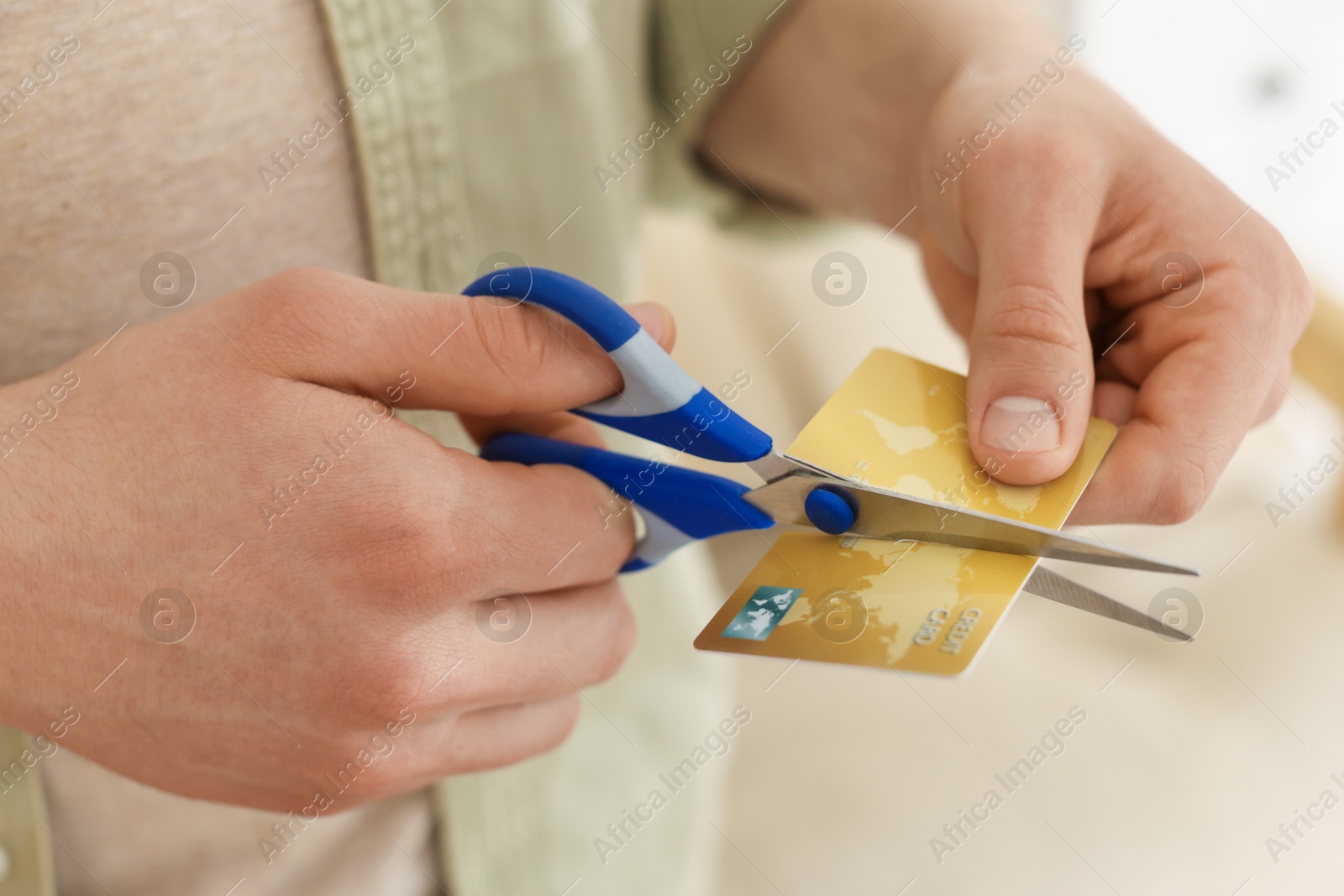 Photo of Man cutting his credit card indoors, closeup