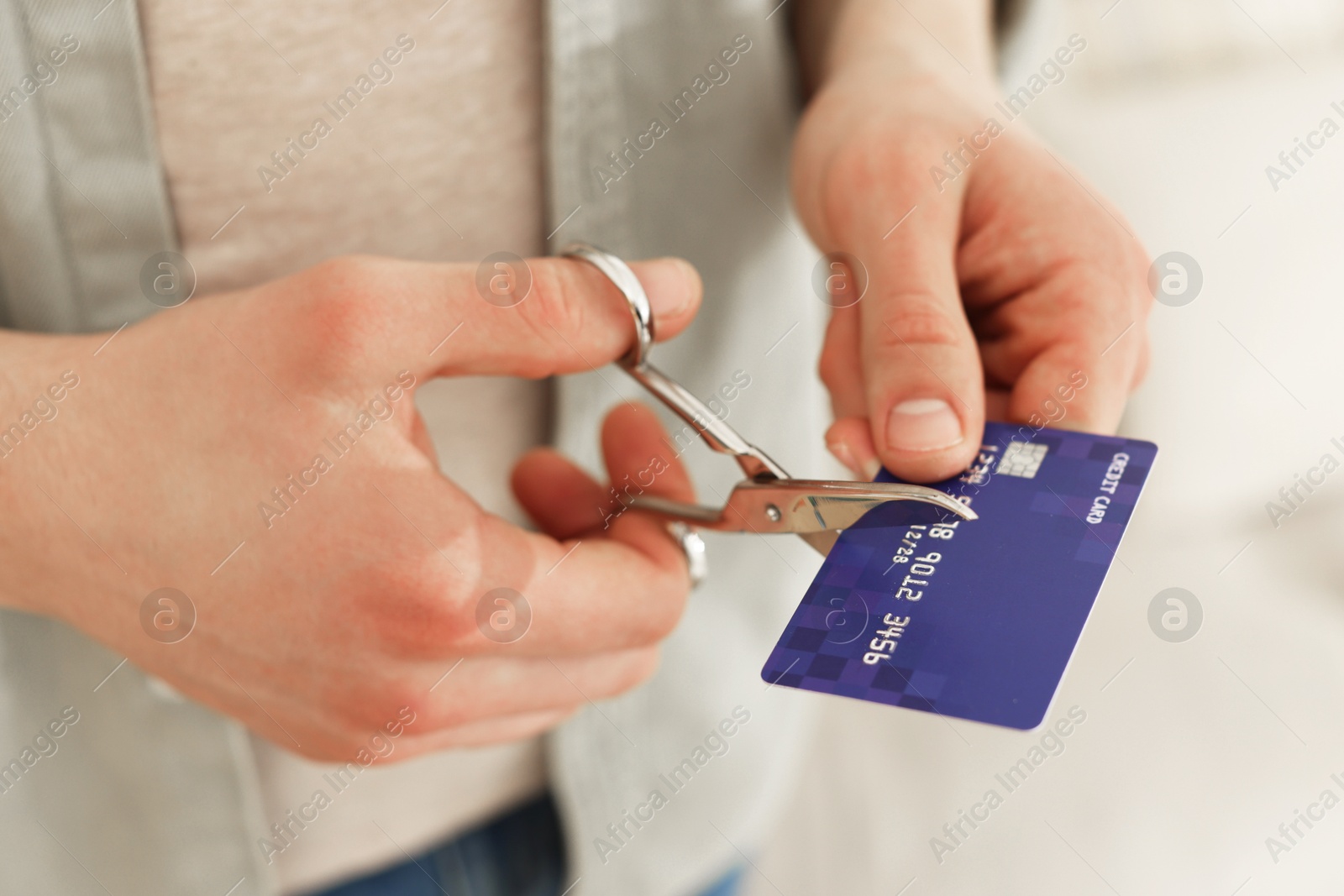 Photo of Man cutting his credit card indoors, closeup