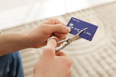 Photo of Man cutting his credit card indoors, closeup