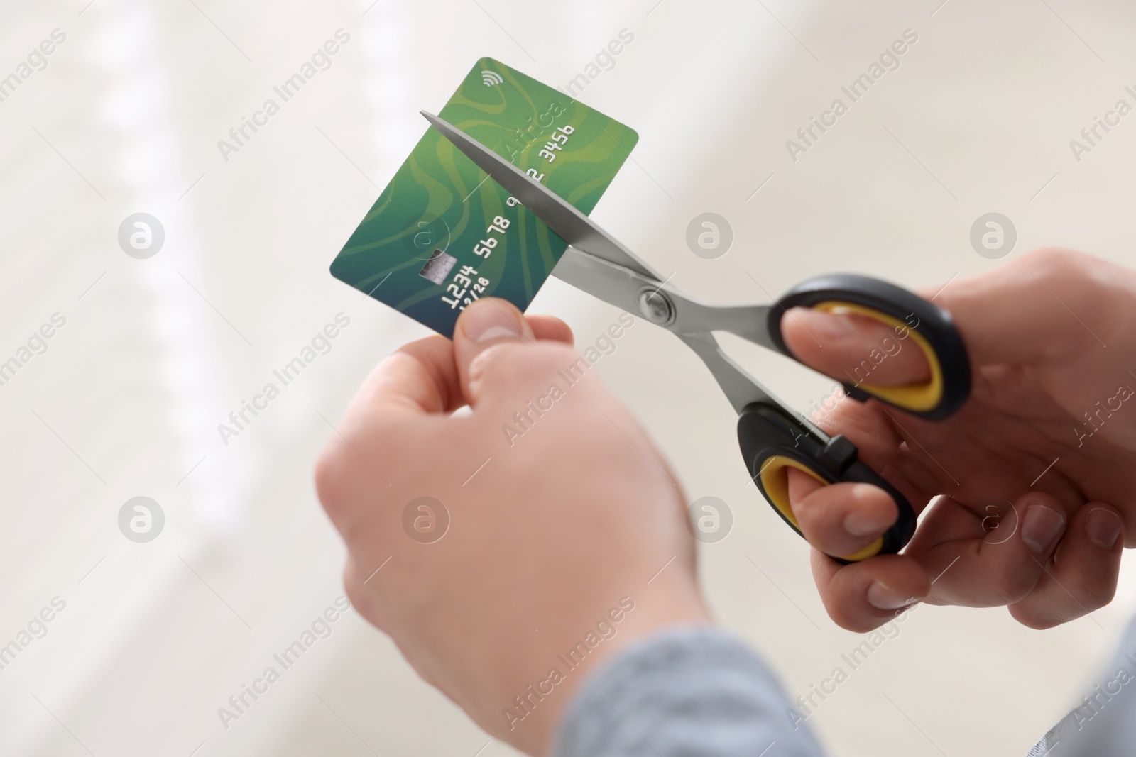 Photo of Man cutting his credit card indoors, closeup