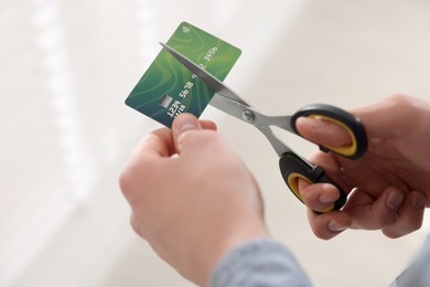 Photo of Man cutting his credit card indoors, closeup