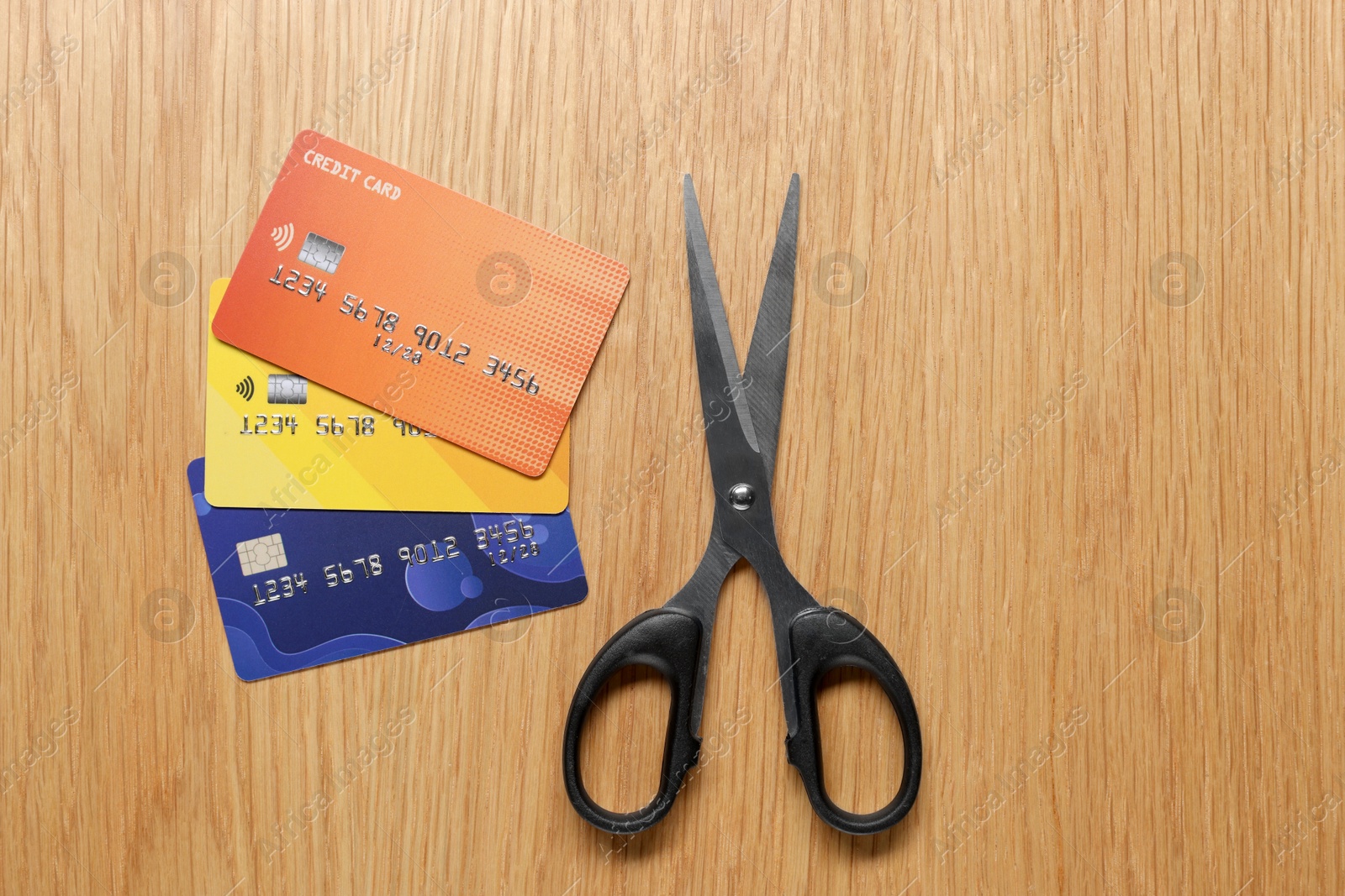 Photo of Credit cards and scissors on wooden table, top view