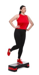 Photo of Plus size woman in gym clothes doing exercise with step platform on white background