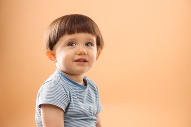 Photo of Portrait of smiling little boy on beige background. Space for text