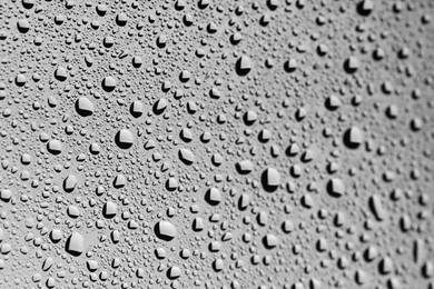 Water drops on grey glass surface, closeup