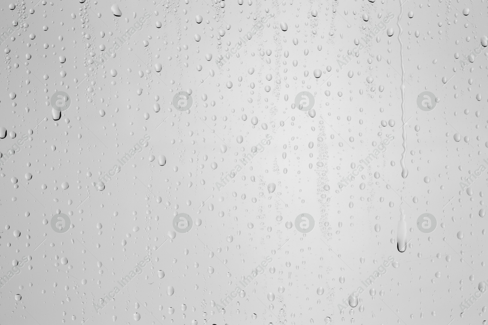 Photo of Water drops on light grey glass surface, top view